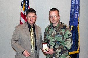 Gerald Tritle, chapter president (l), presents Tech Sgt. Michael Fay, USAF, with a gold watch for being selected the regional Distinguished Young AFCEAN.
